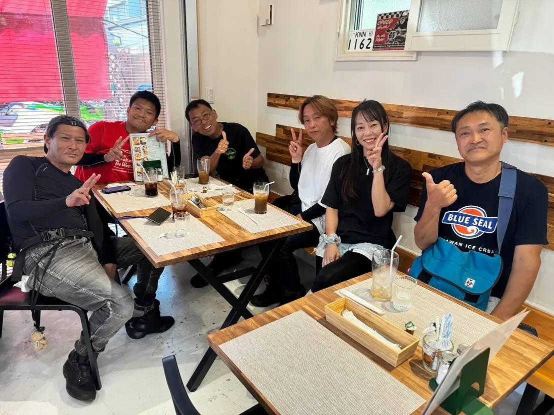 木のテーブルを囲んで過ごす人たち